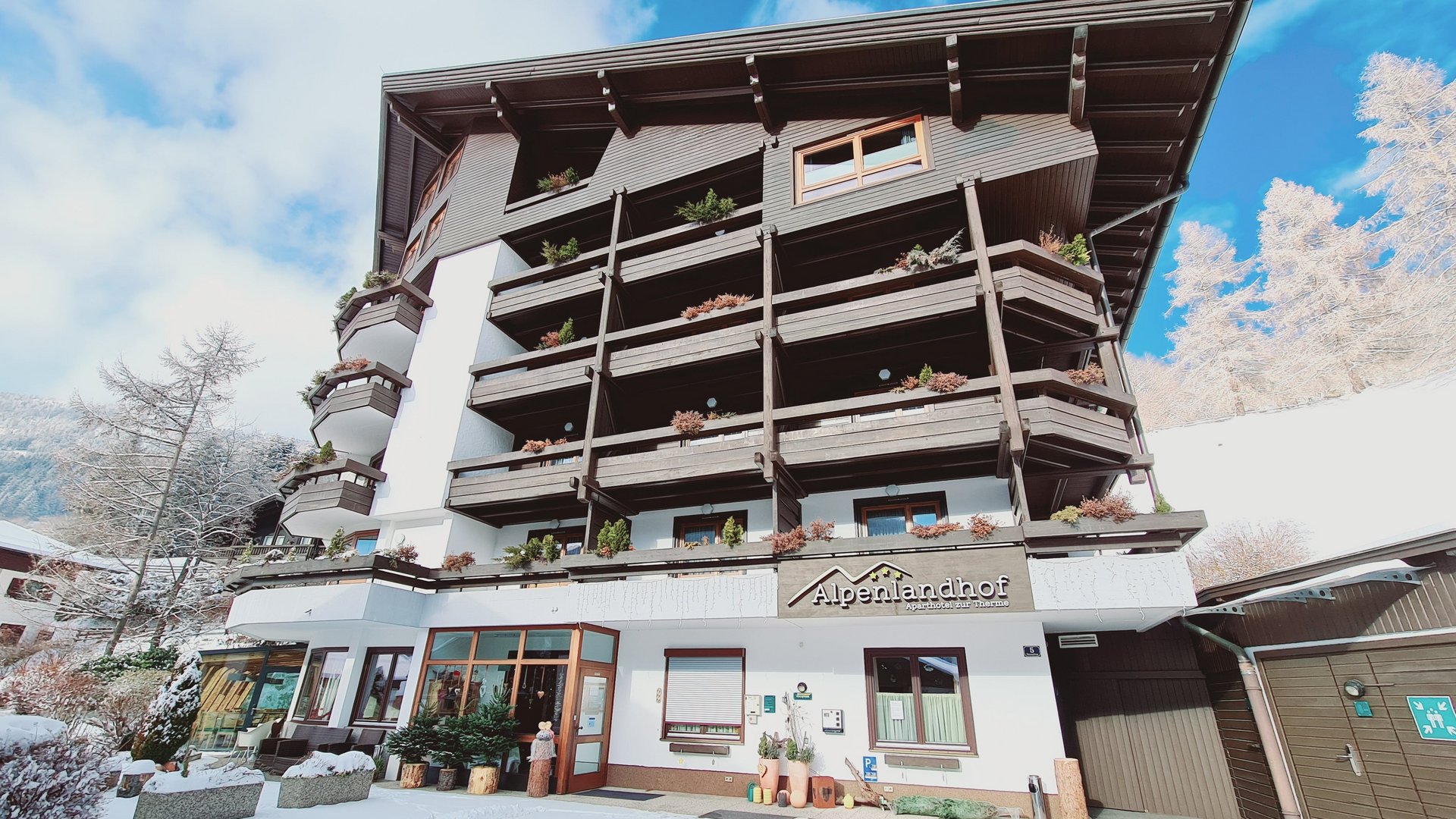 Alpenlandhof Winterzauber Traditionelles Alpenhotel mit hölzernen Balkonen im verschneiten Bad Kleinkirchheim.